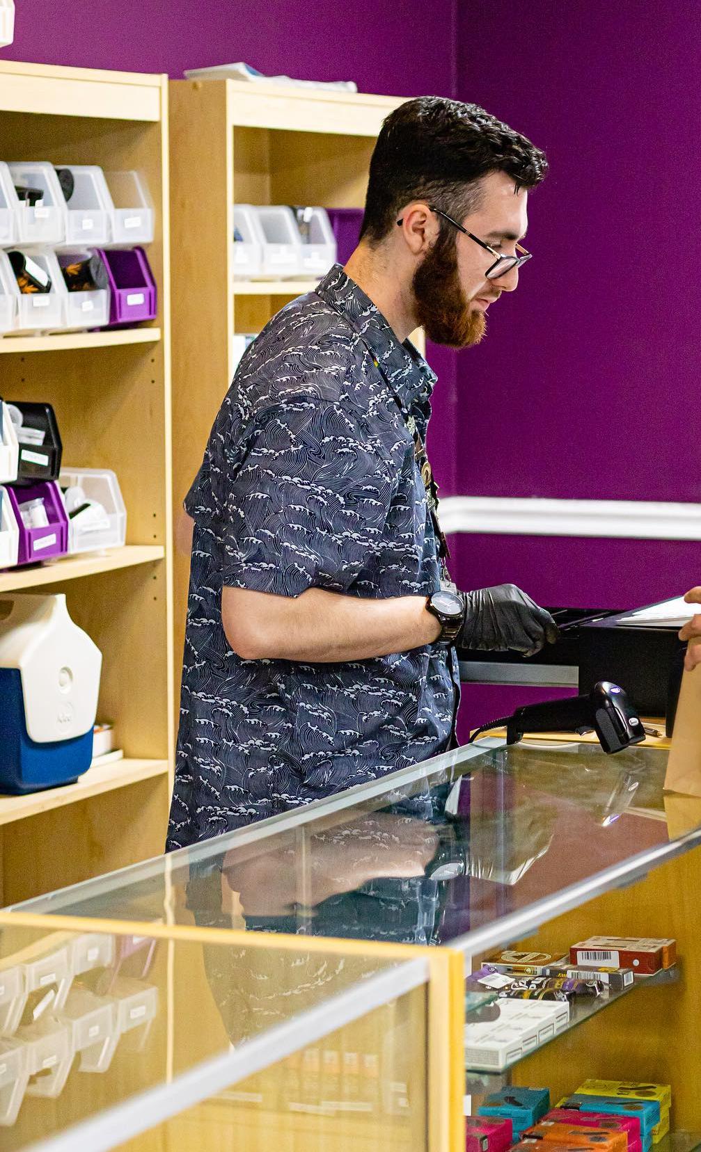 A budtender serving a customer at Better Health Group